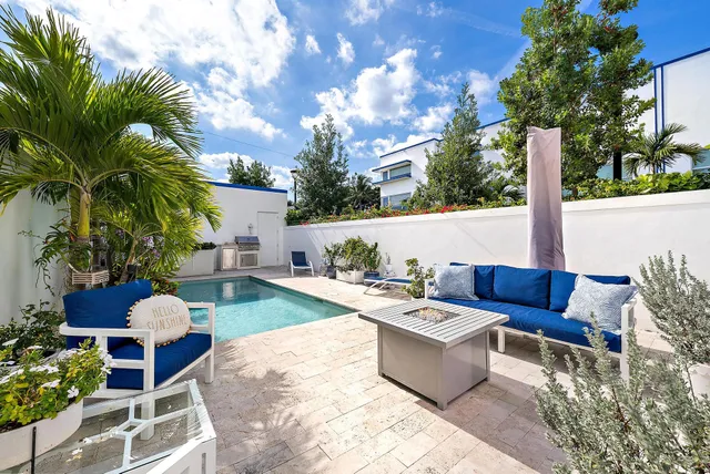 a view of a patio with couches table and chairs potted plants and palm trees