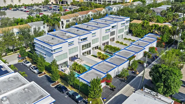 an aerial view of a multi story residential apartment building with yard