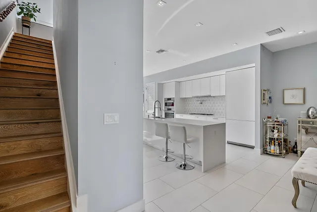 a kitchen with white cabinets and sink