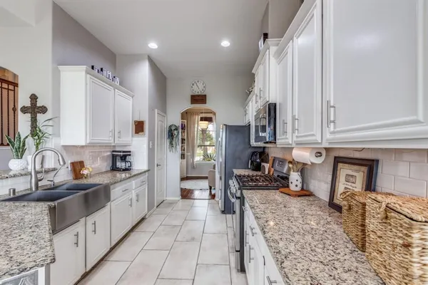 a kitchen with stainless steel appliances granite countertop a sink stove and cabinets