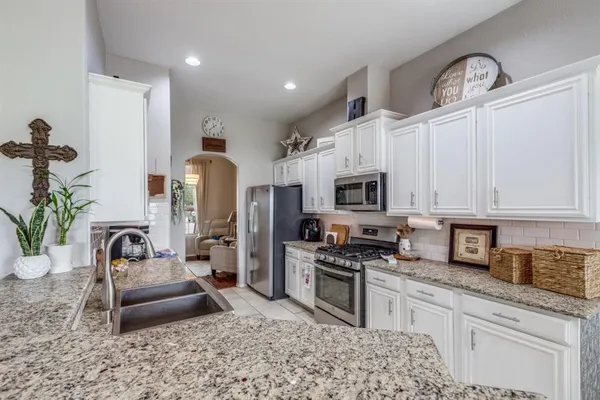 a kitchen with stainless steel appliances granite countertop a stove a sink a refrigerator and a granite counter tops