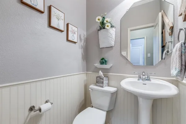 a bathroom with a sink mirror and toilet