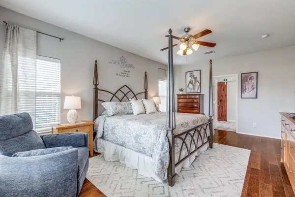 a bedroom with a large bed a chandelier and a couch