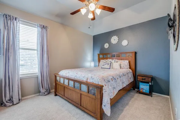 a bedroom with a bed a chandelier and a window