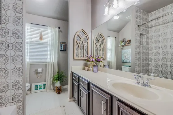 a bathroom with double vanity and a mirror