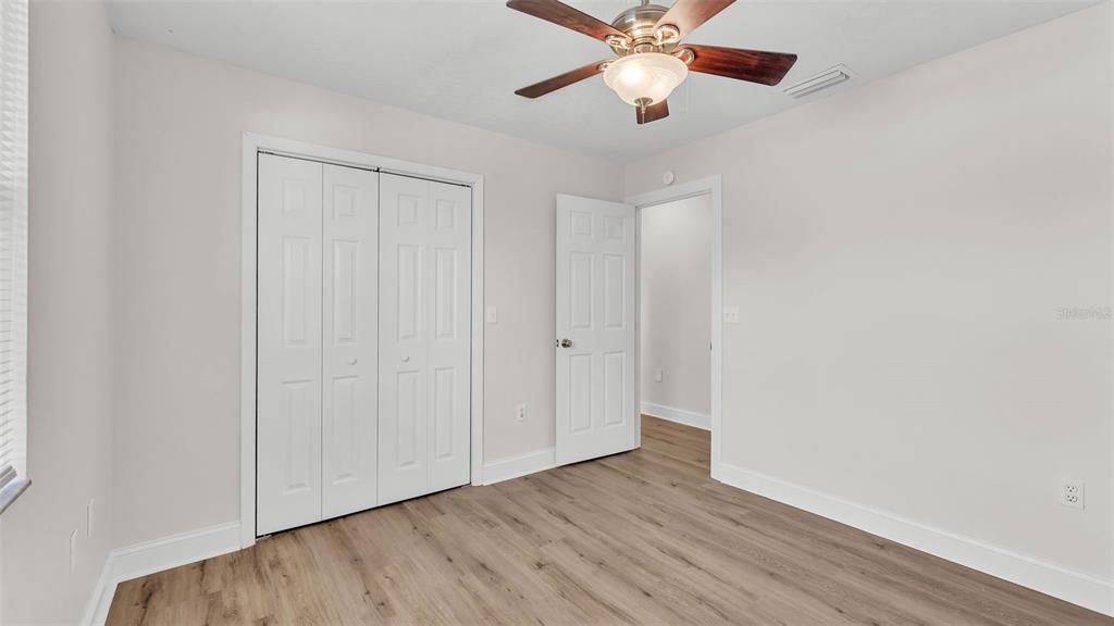 3806 Bent Tree Loop West Lakeland, FL 33813 - Photo 13 of 58 an empty room with wooden floor fan and windows