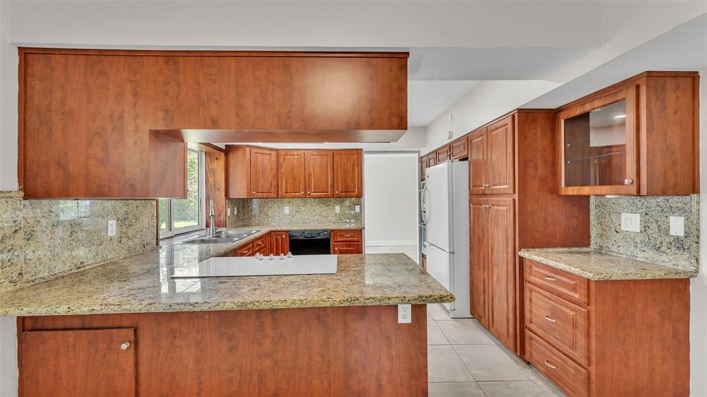 3806 Bent Tree Loop West Lakeland, FL 33813 - Photo 33 of 58 a kitchen with stainless steel appliances granite countertop a sink and a wooden cabinets