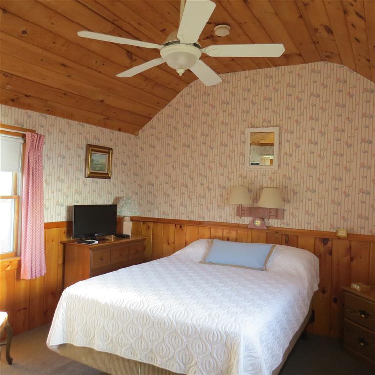 168 Shore Road, Unit 10 Truro, MA 02666 - Photo 6 of 9 a bedroom with a bed and wooden floor