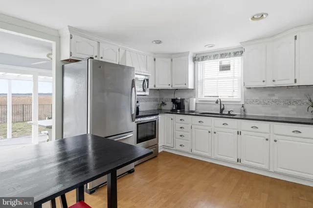 a kitchen with granite countertop white cabinets and sink