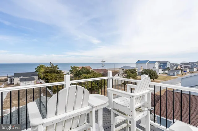 a view of a house with white door and a wooden bench