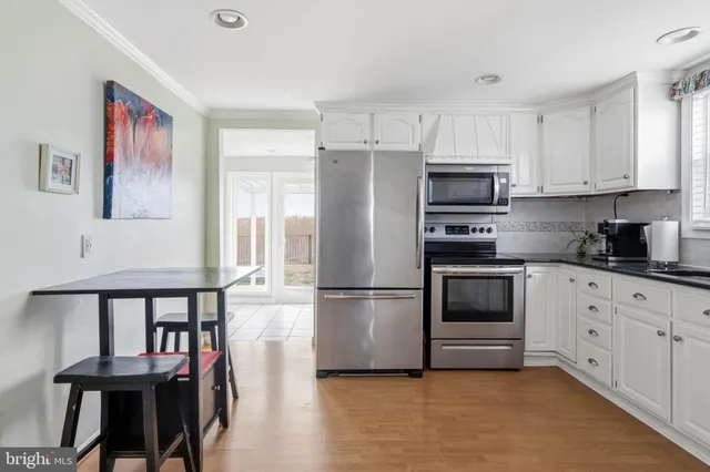 a kitchen with stainless steel appliances a refrigerator and a stove top oven