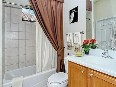 a bathroom with a granite countertop sink a toilet and shower