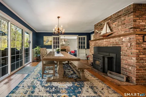 a living room with furniture a dining table and a fireplace