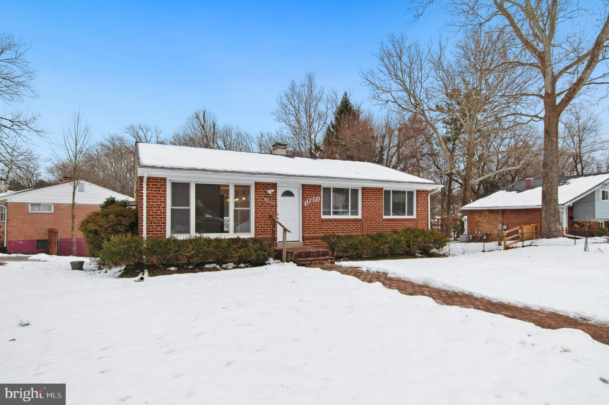 11709 Mentone Road Silver Spring, MD 20906 - Photo 3 of 4 a front view of a house with a yard covered with snow