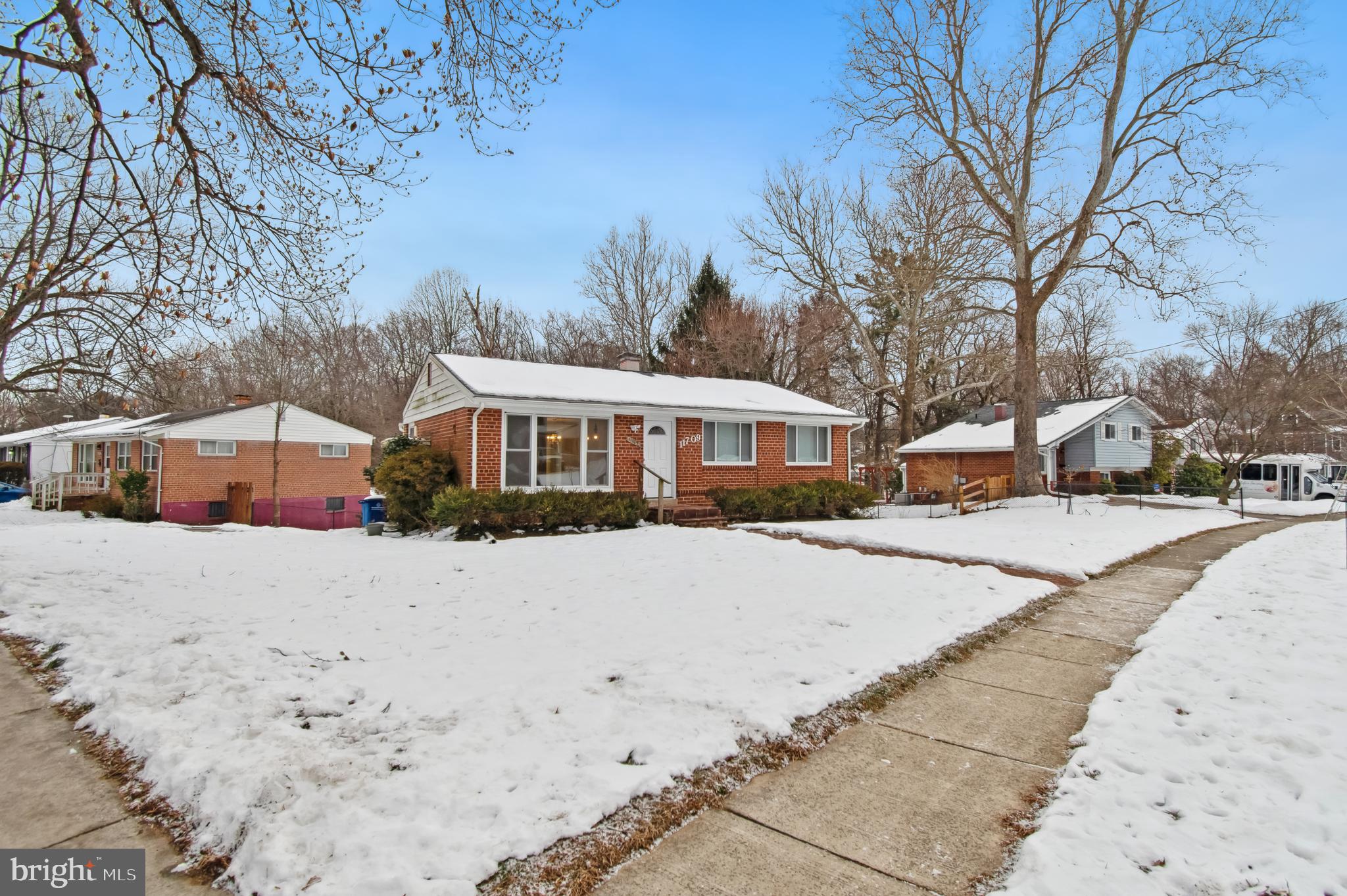 11709 Mentone Road Silver Spring, MD 20906 - Photo 4 of 4 a front view of a house with a yard covered in snow