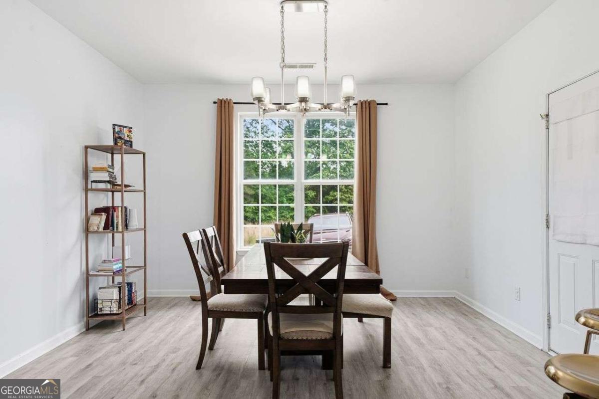 166 Odyssey Conyers, GA 30012 - Photo 16 of 42 a view of a dining room with furniture window and wooden floor