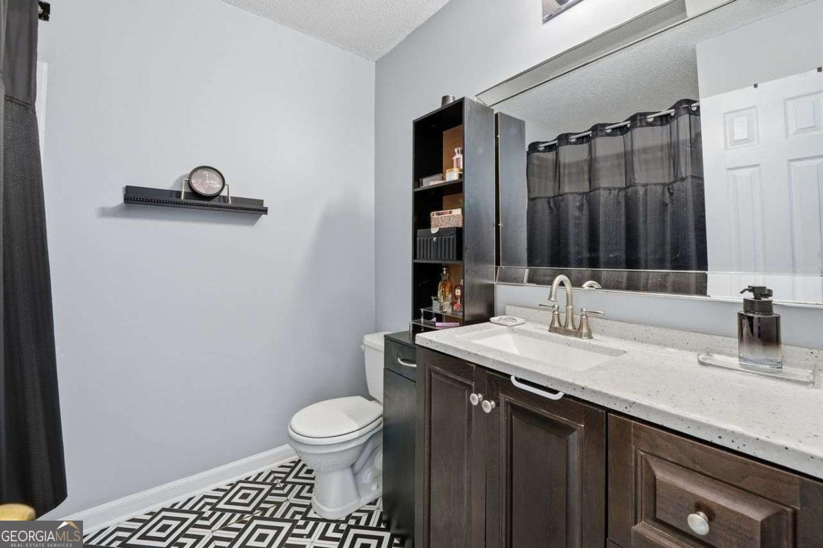 166 Odyssey Conyers, GA 30012 - Photo 26 of 42 a bathroom with a granite countertop sink toilet and a mirror