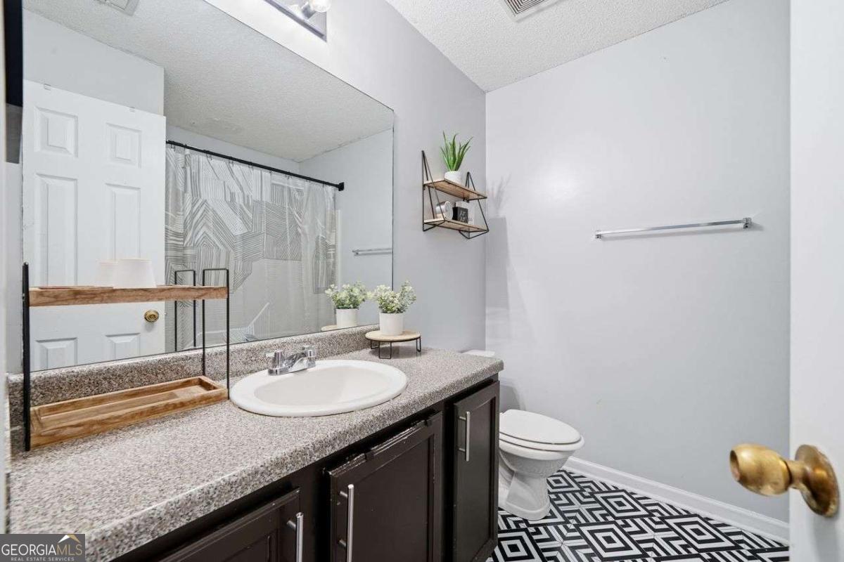 166 Odyssey Conyers, GA 30012 - Photo 31 of 42 a bathroom with a granite countertop sink and a mirror