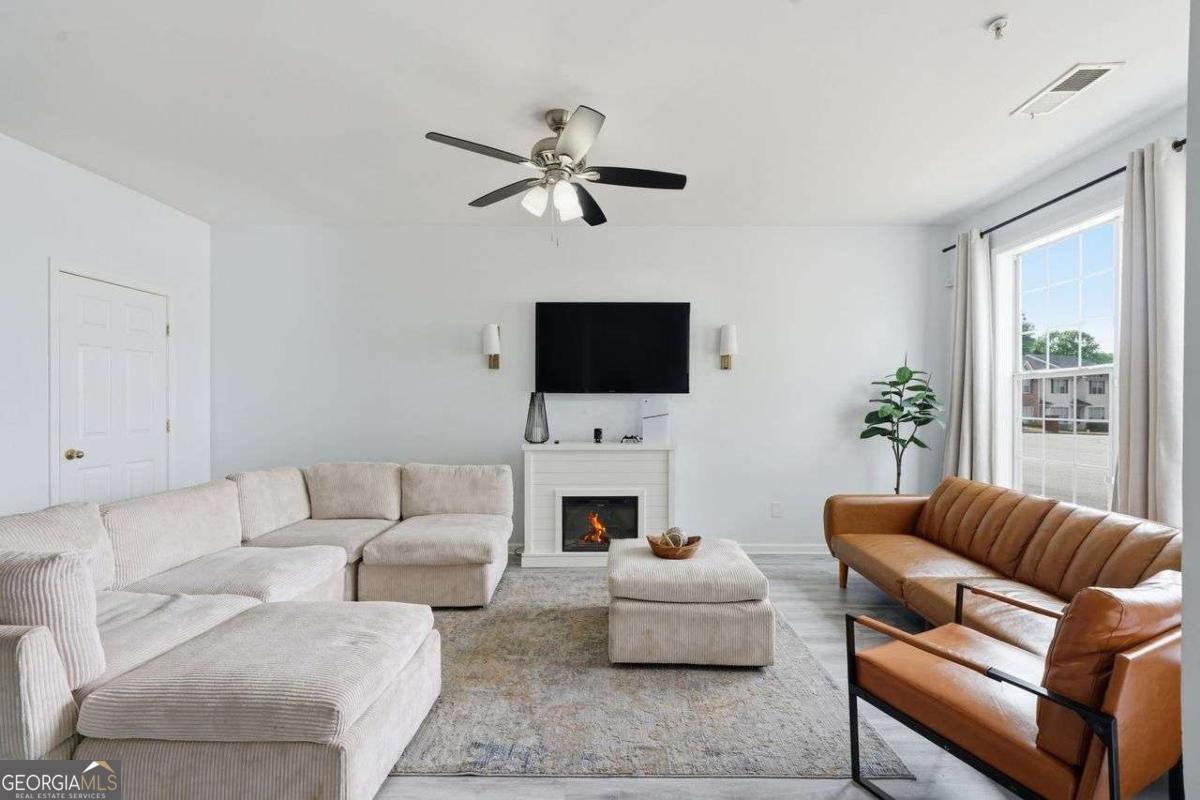 166 Odyssey Conyers, GA 30012 - Photo 8 of 42 a living room with furniture a fireplace and a flat screen tv