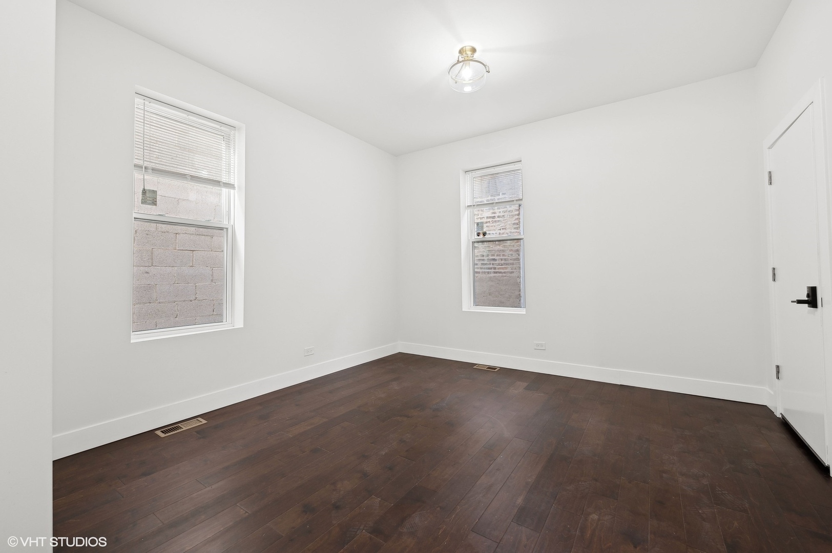 2313 West Fullerton Avenue Chicago, IL 60647 - Photo 15 of 25 an empty room with wooden floor and windows
