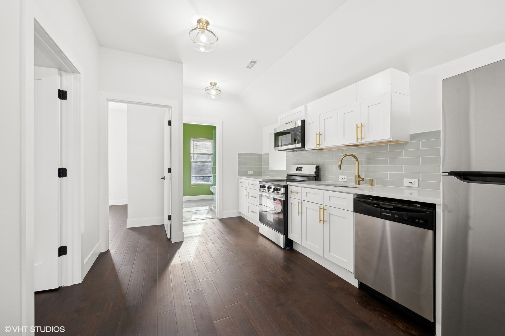 2313 West Fullerton Avenue Chicago, IL 60647 - Photo 17 of 25 a kitchen with granite countertop a refrigerator a sink dishwasher and a stove with wooden floor
