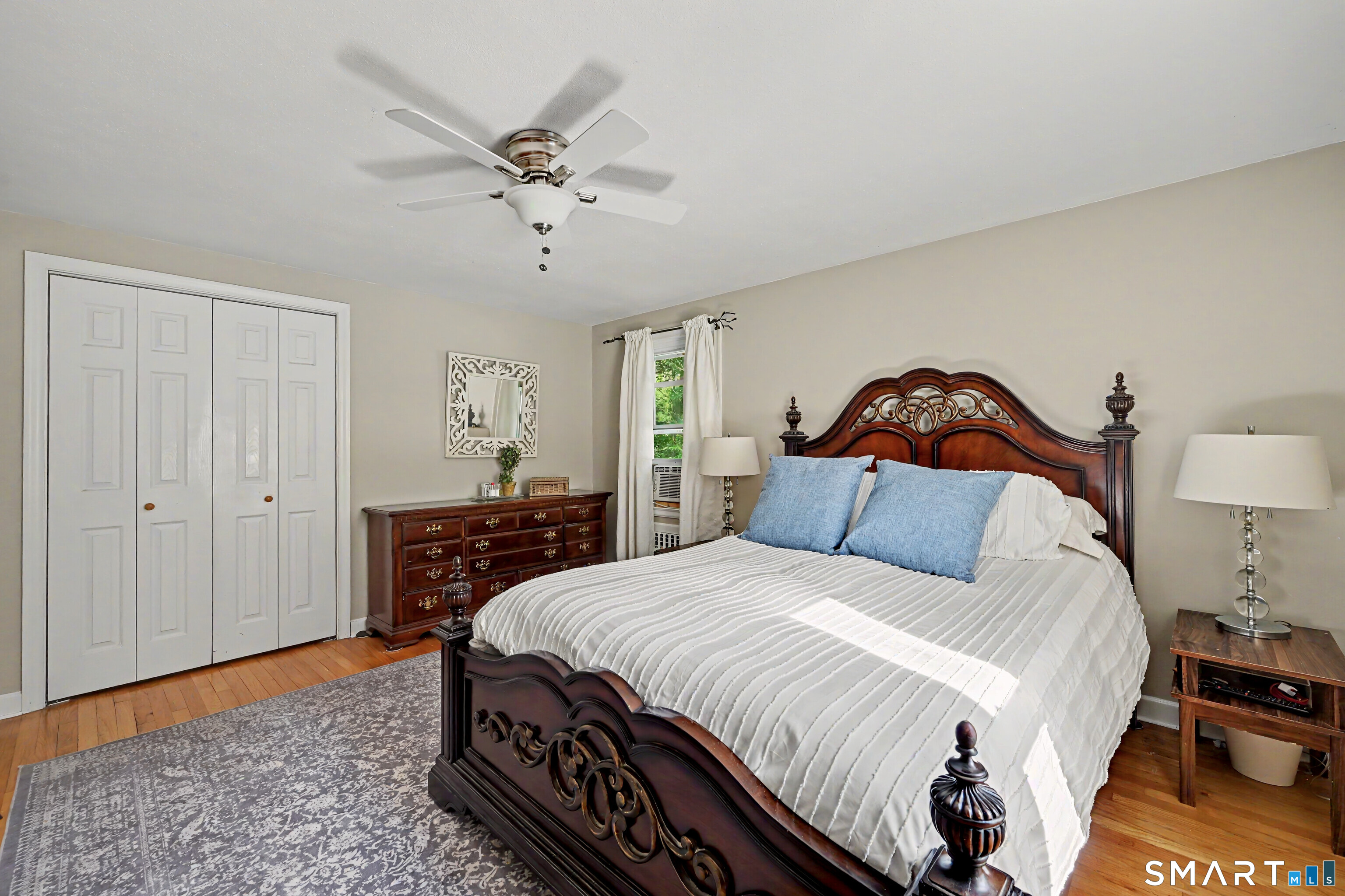 524 Ferry Road Orange, CT 06477 - Photo 25 of 40 a bedroom with a bed and a chandelier