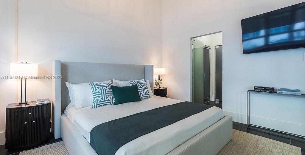 2001 Biscayne Boulevard, Unit 2104 Miami, FL 33137 - Photo 10 of 17 a bedroom with a bed and a night stand