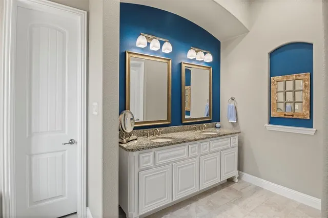 a bathroom with a granite countertop sink and a mirror