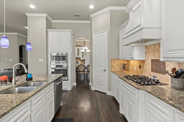 a kitchen with stainless steel appliances kitchen island granite countertop a sink stove and cabinets