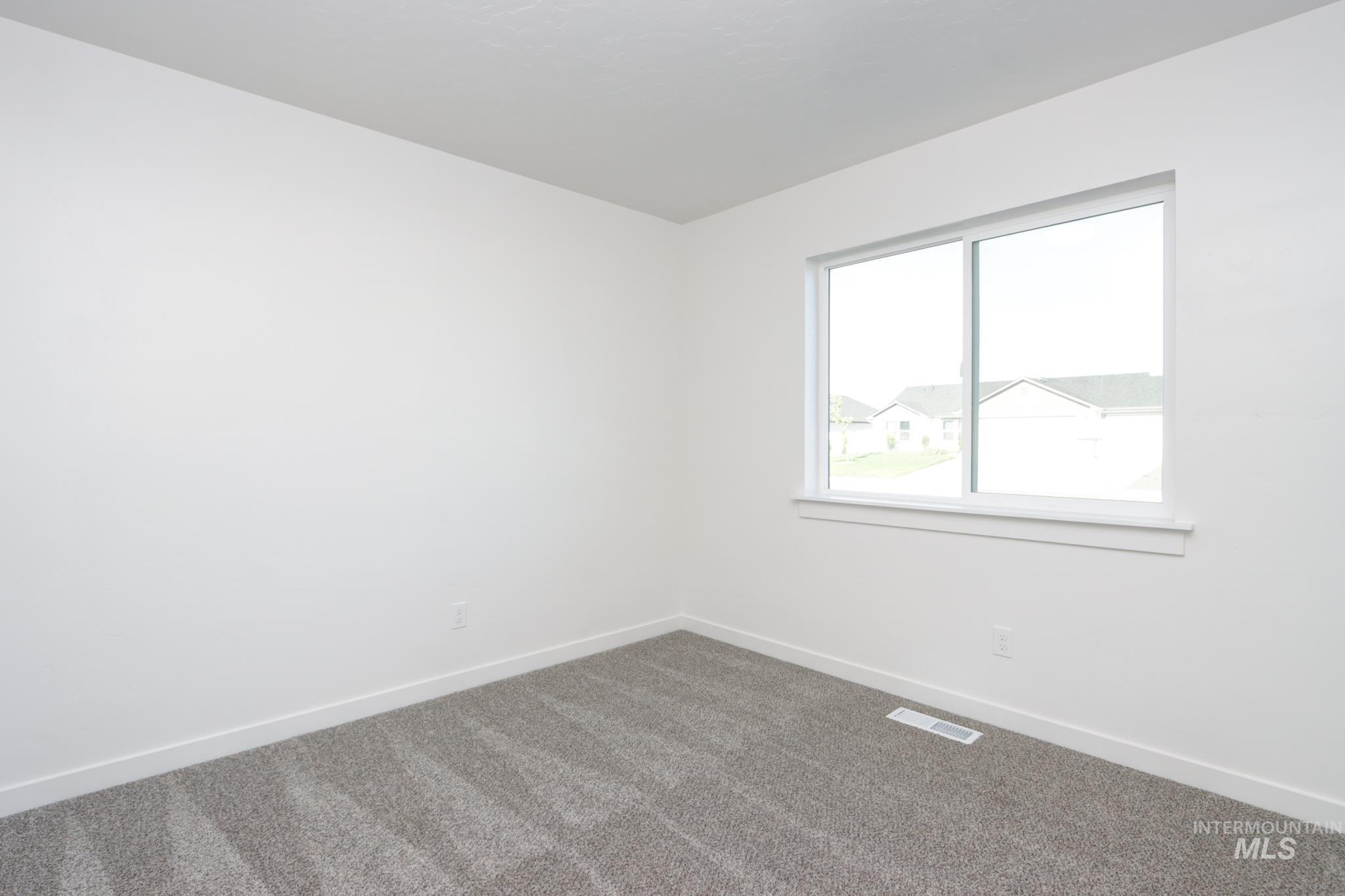 848 North 5th Street Nyssa, OR 97913 - Photo 28 of 49 Room featuring a white painted wall, gray patterned carpet, and a large window with white trim