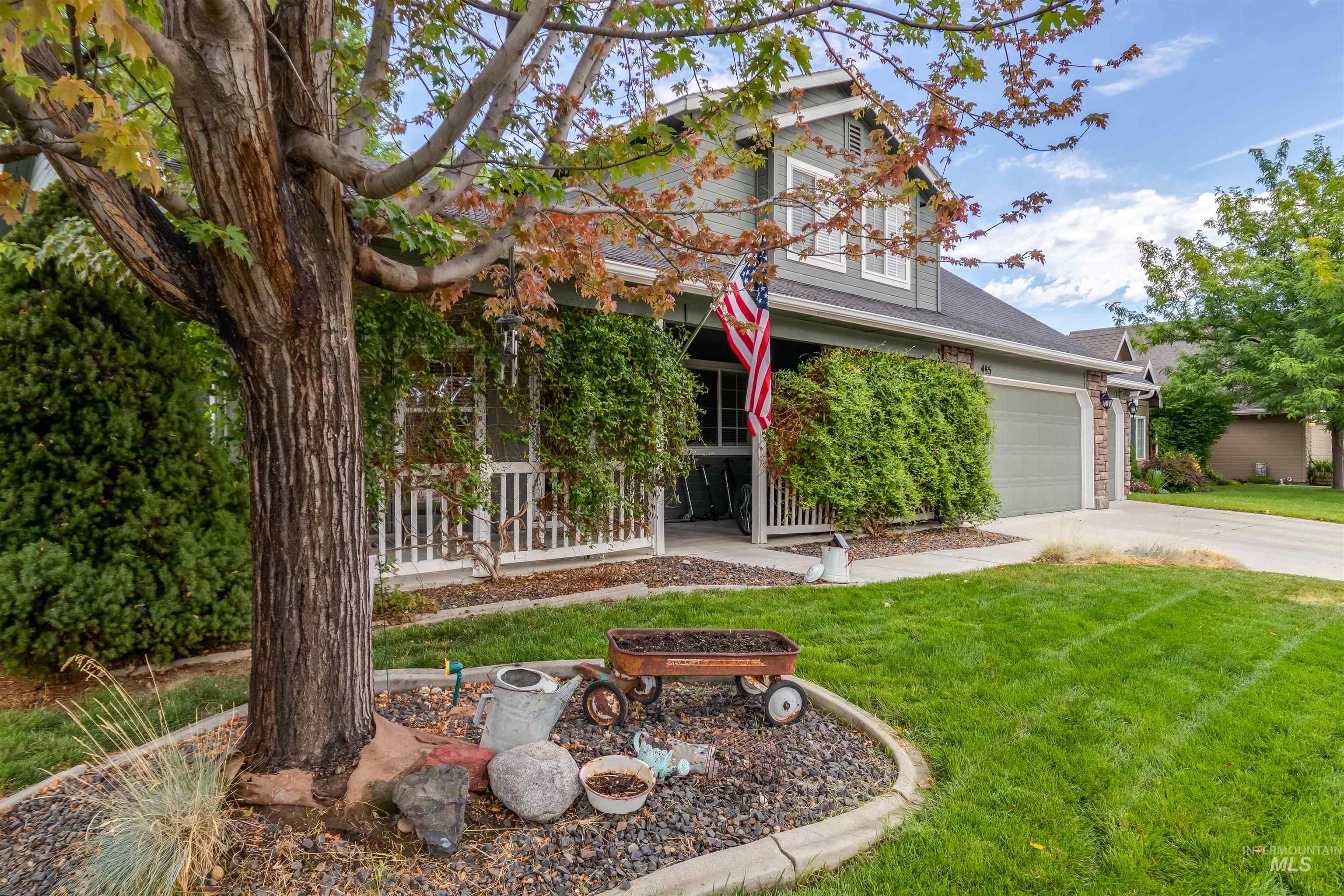 485 North Nebula Avenue Star, ID 83669 - Photo 1 of 47 View of property hidden behind natural elements with a front yard, concrete driveway, a porch, and a shingled roof