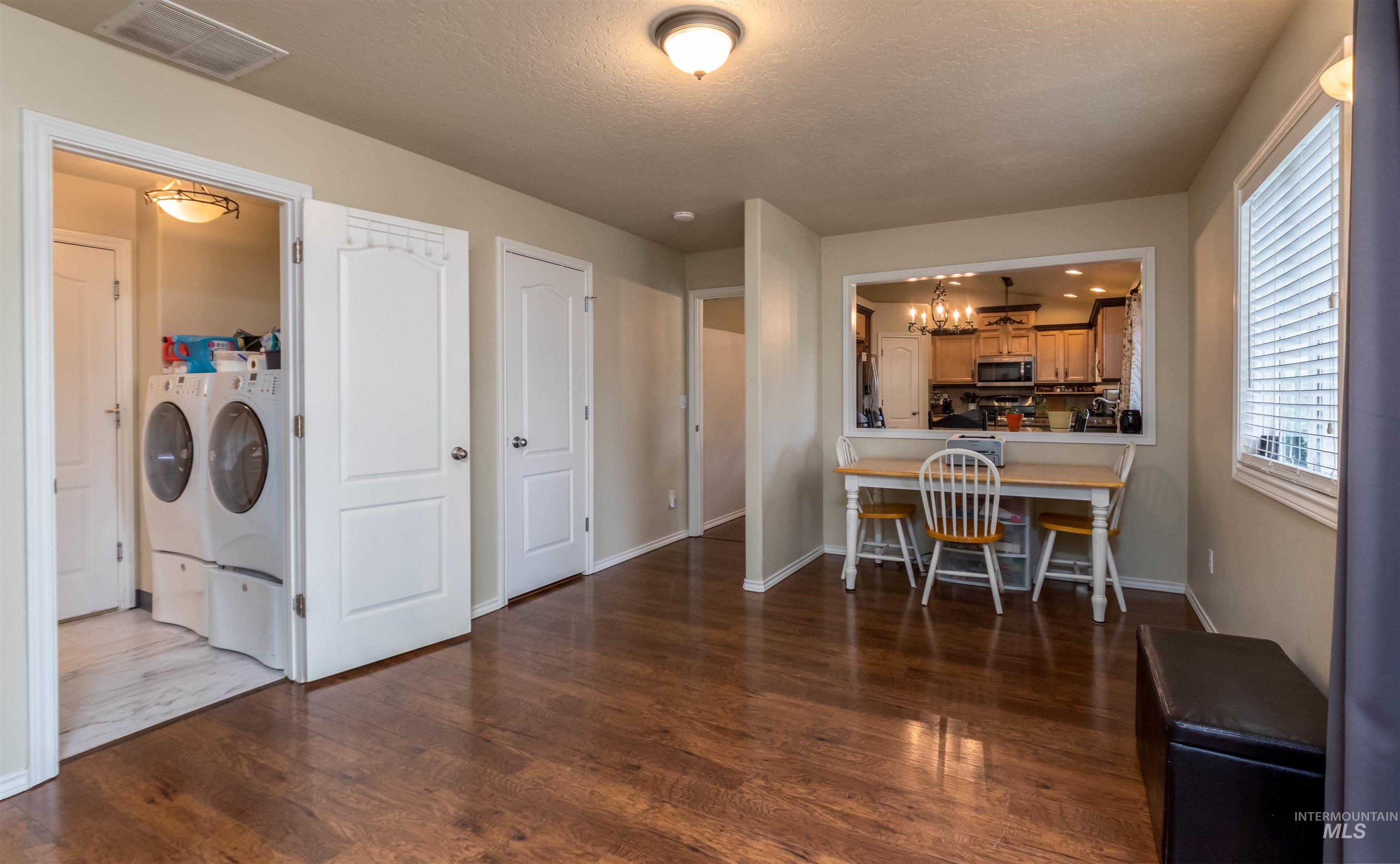 485 North Nebula Avenue Star, ID 83669 - Photo 12 of 47 Laundry area featuring separate washer and dryer, wood finished floors, a textured ceiling, and a chandelier