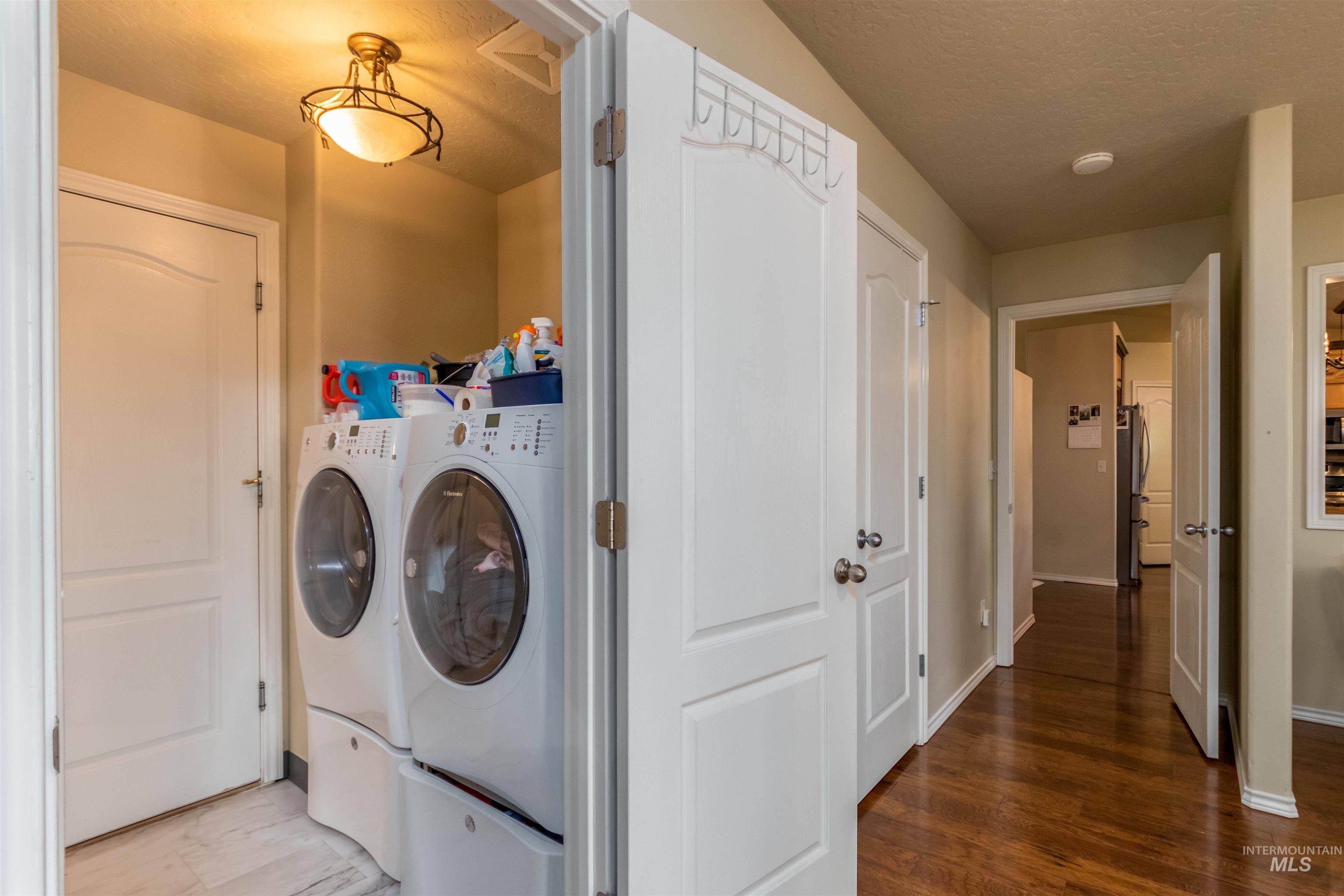 485 North Nebula Avenue Star, ID 83669 - Photo 13 of 47 Laundry room featuring washing machine and dryer, a textured ceiling, and wood finished floors