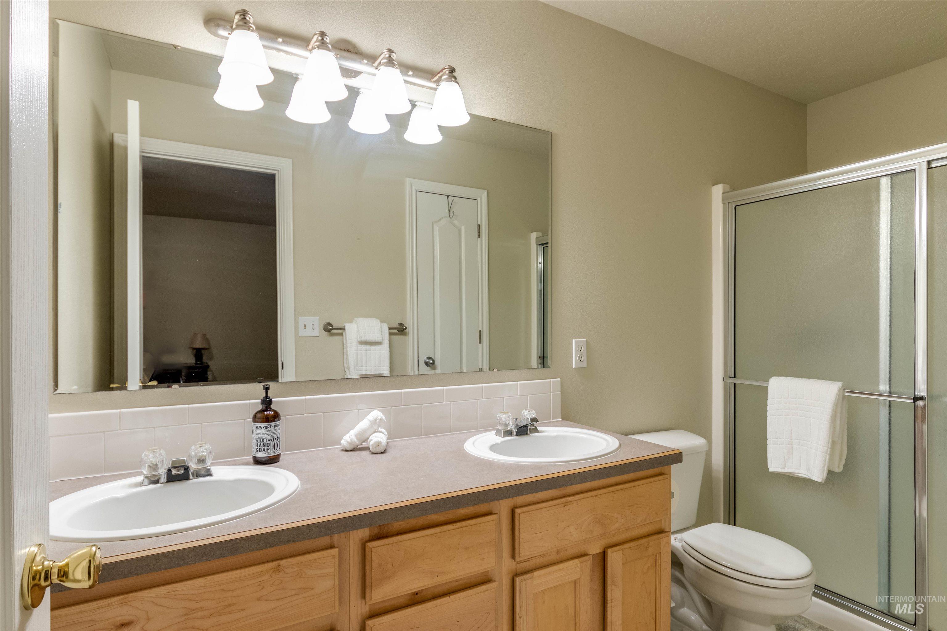 485 North Nebula Avenue Star, ID 83669 - Photo 18 of 47 Bathroom featuring double vanity, a stall shower, and decorative backsplash