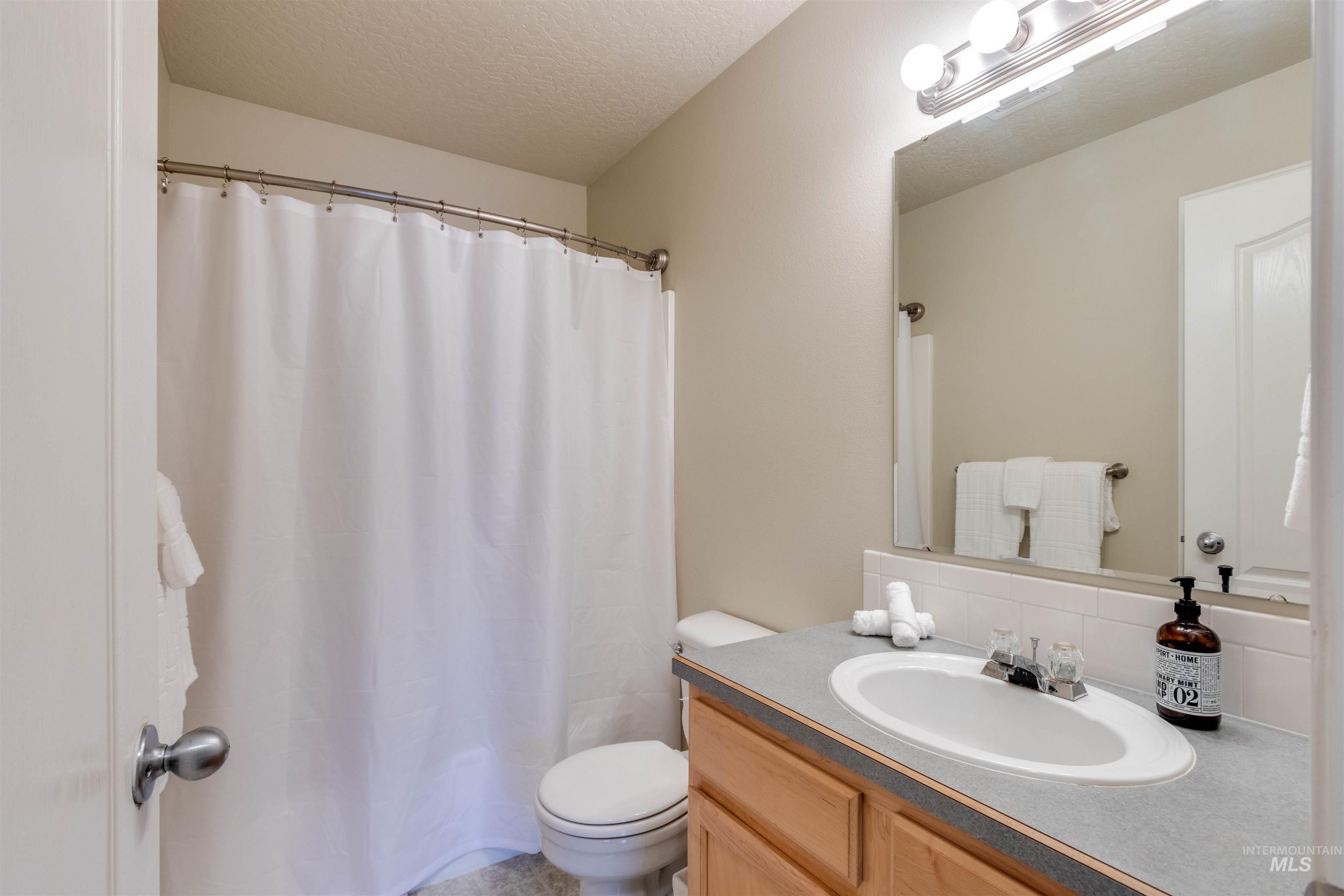 485 North Nebula Avenue Star, ID 83669 - Photo 21 of 47 Full bathroom featuring a textured ceiling, vanity, and backsplash