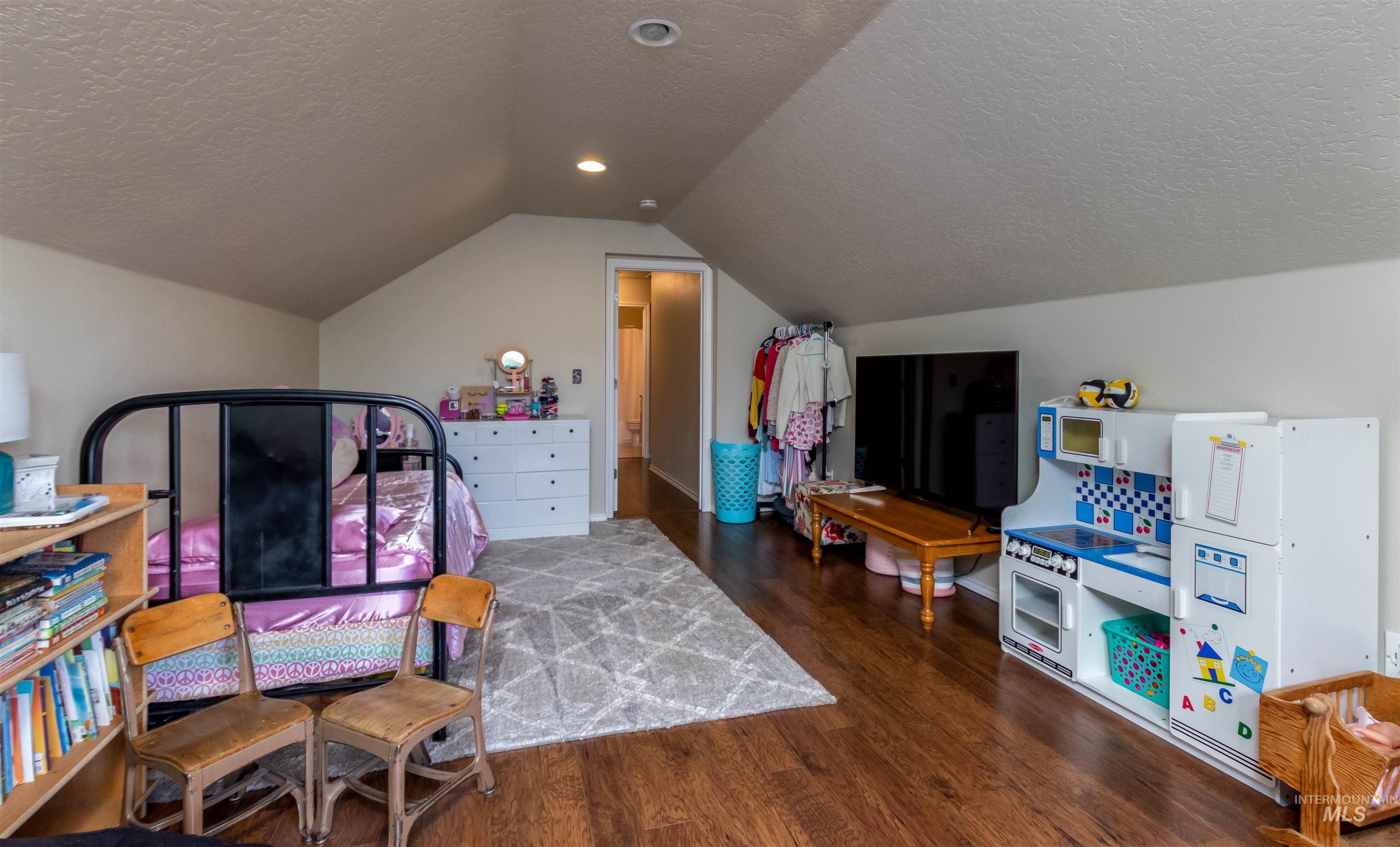 485 North Nebula Avenue Star, ID 83669 - Photo 22 of 47 Bedroom featuring wood finished floors, a textured ceiling, and vaulted ceiling