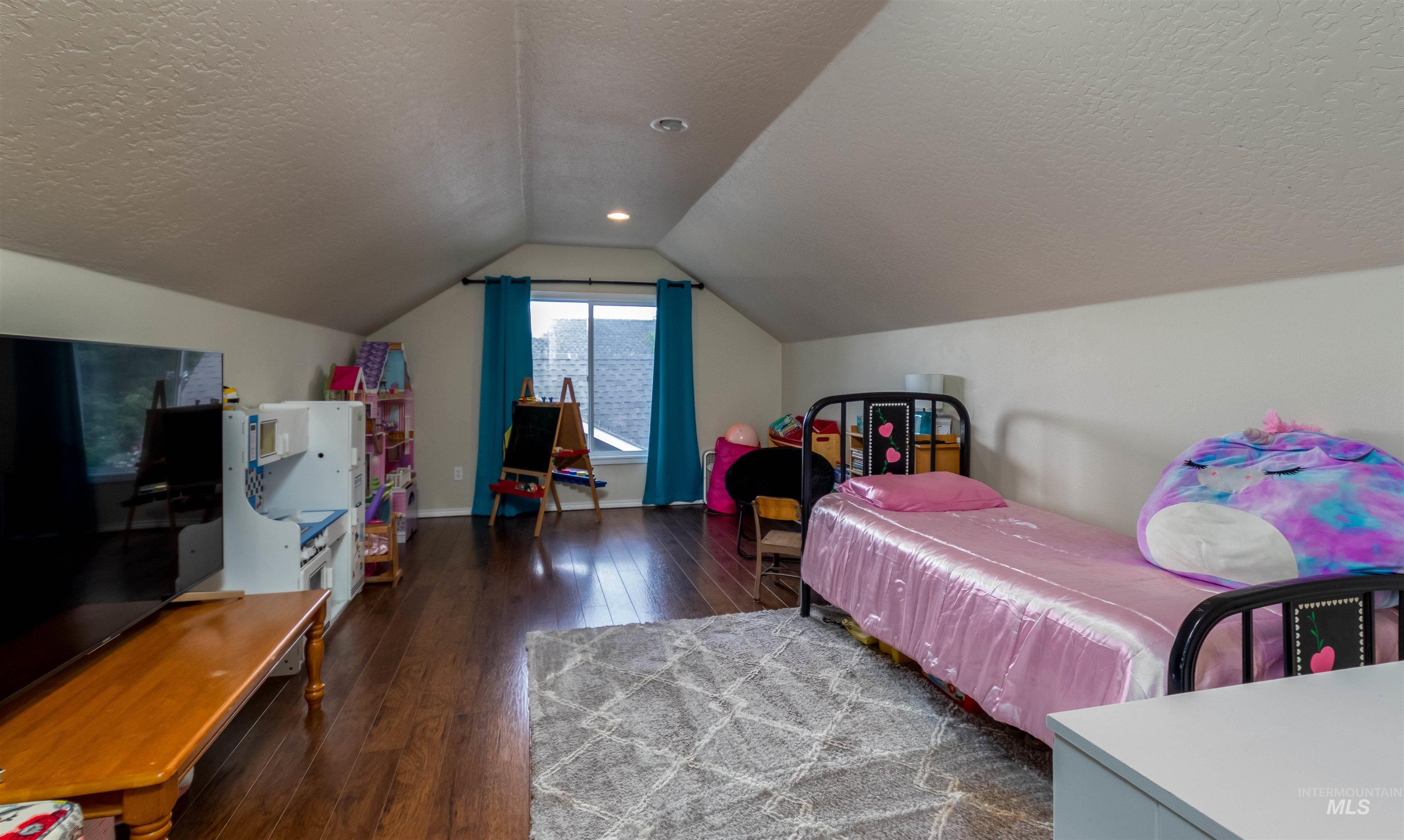 485 North Nebula Avenue Star, ID 83669 - Photo 23 of 47 Bedroom featuring wood-type flooring, a textured ceiling, and lofted ceiling