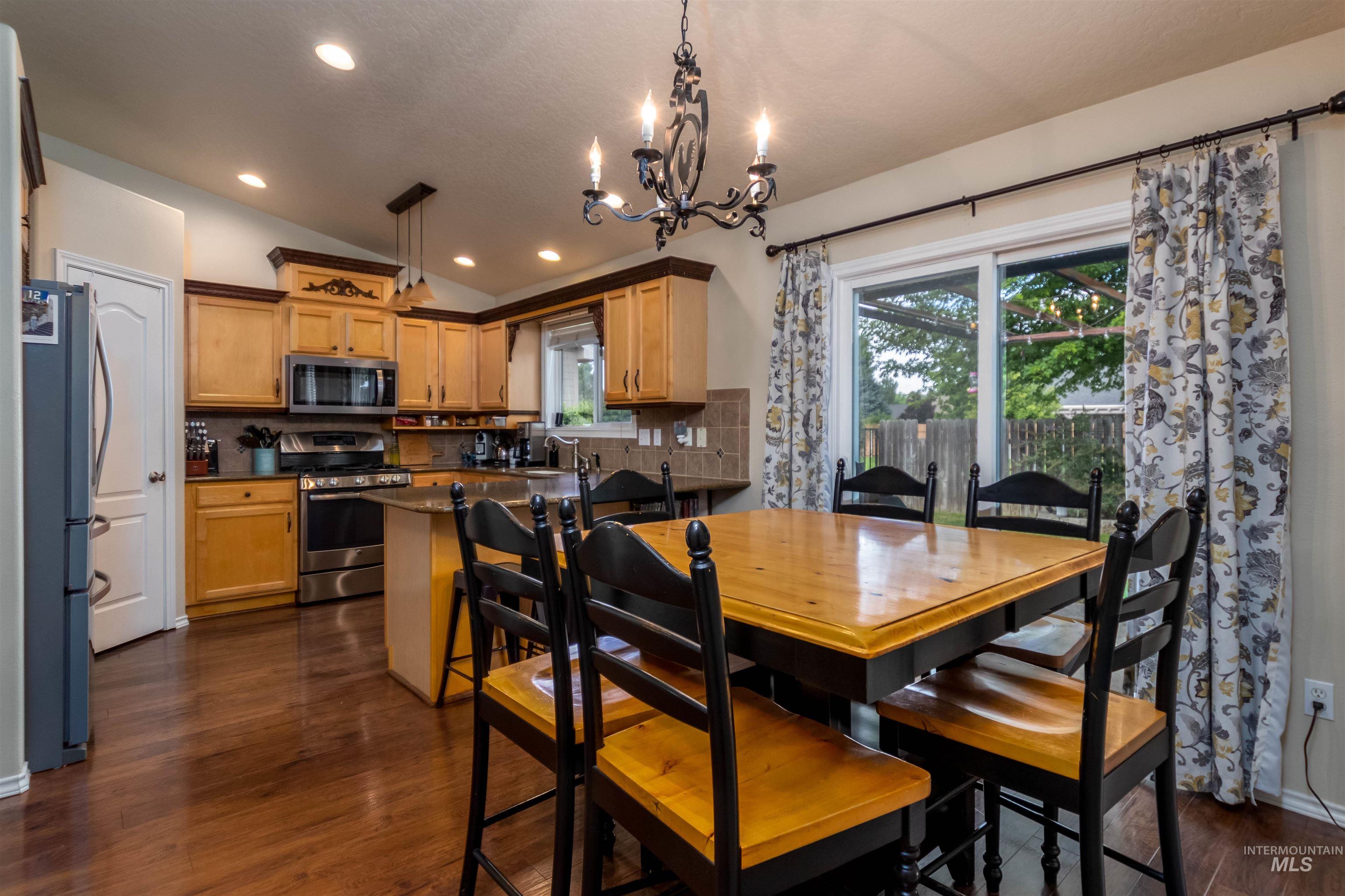 485 North Nebula Avenue Star, ID 83669 - Photo 6 of 47 Dining room with lofted ceiling, a chandelier, dark wood-style floors, and recessed lighting