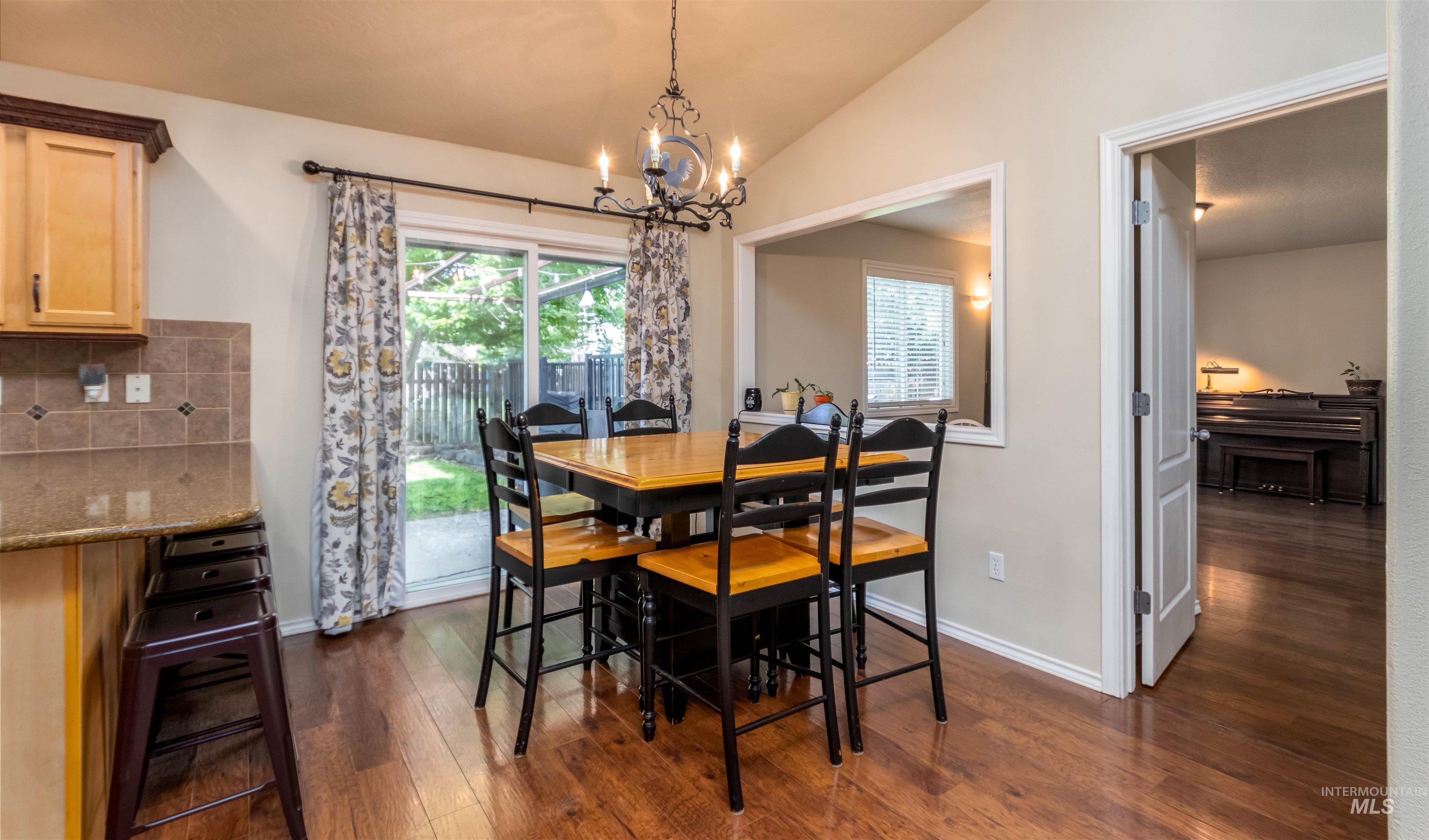 485 North Nebula Avenue Star, ID 83669 - Photo 8 of 47 Dining space featuring vaulted ceiling, a chandelier, and dark wood-type flooring
