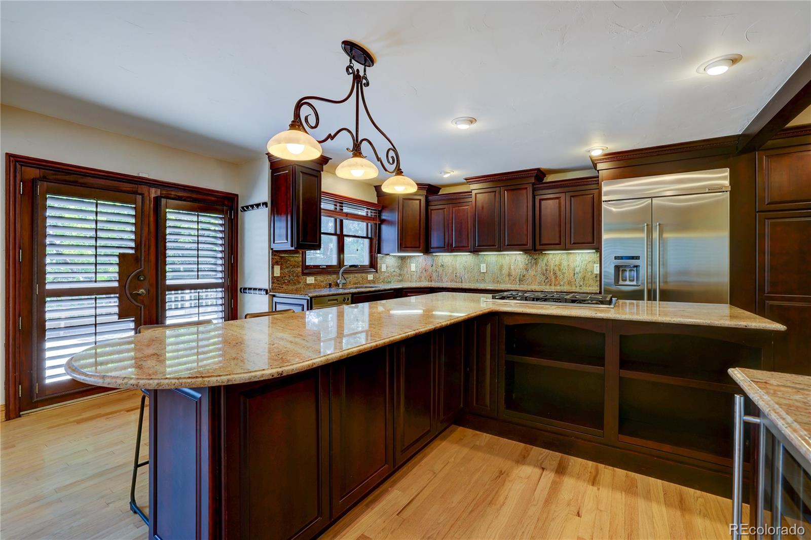 8844 South Forrest Drive Highlands Ranch, CO 80126 - Photo 14 of 40 a kitchen with kitchen island granite countertop a sink cabinets and stainless steel appliances