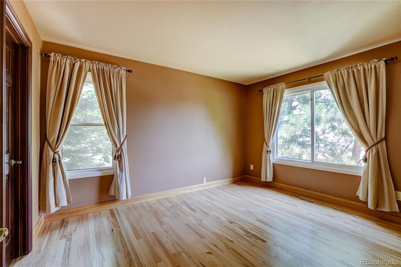 8844 South Forrest Drive Highlands Ranch, CO 80126 - Photo 30 of 40 an empty room with wooden floor and a window