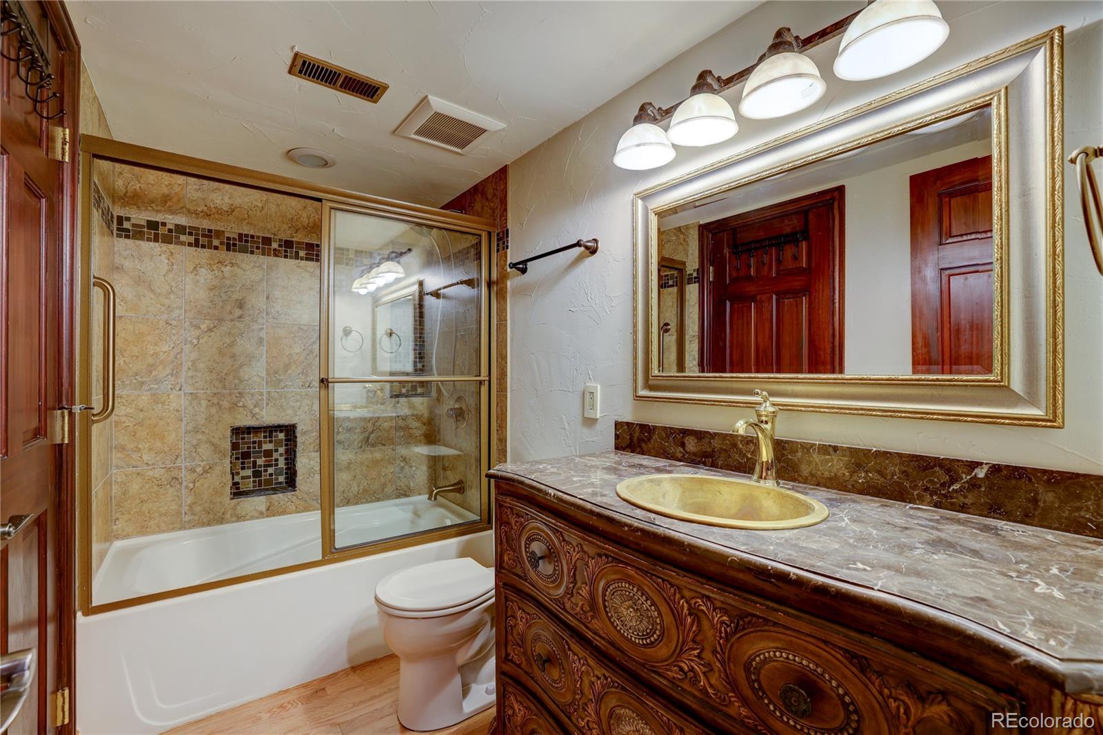 8844 South Forrest Drive Highlands Ranch, CO 80126 - Photo 31 of 40 a bathroom with a granite countertop sink toilet and shower