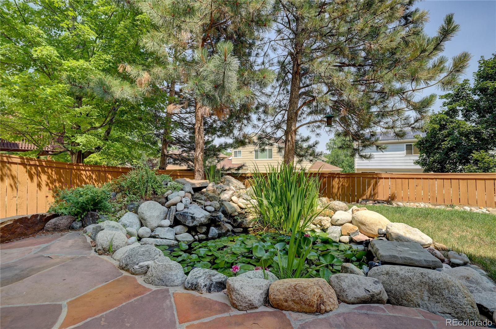 8844 South Forrest Drive Highlands Ranch, CO 80126 - Photo 35 of 40 a view of a garden filled with plants and a bench
