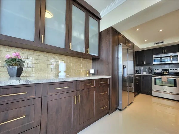 a kitchen with stainless steel appliances a sink stove and refrigerator