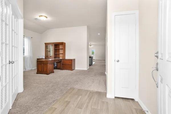 a view of an empty room with cabinet and door