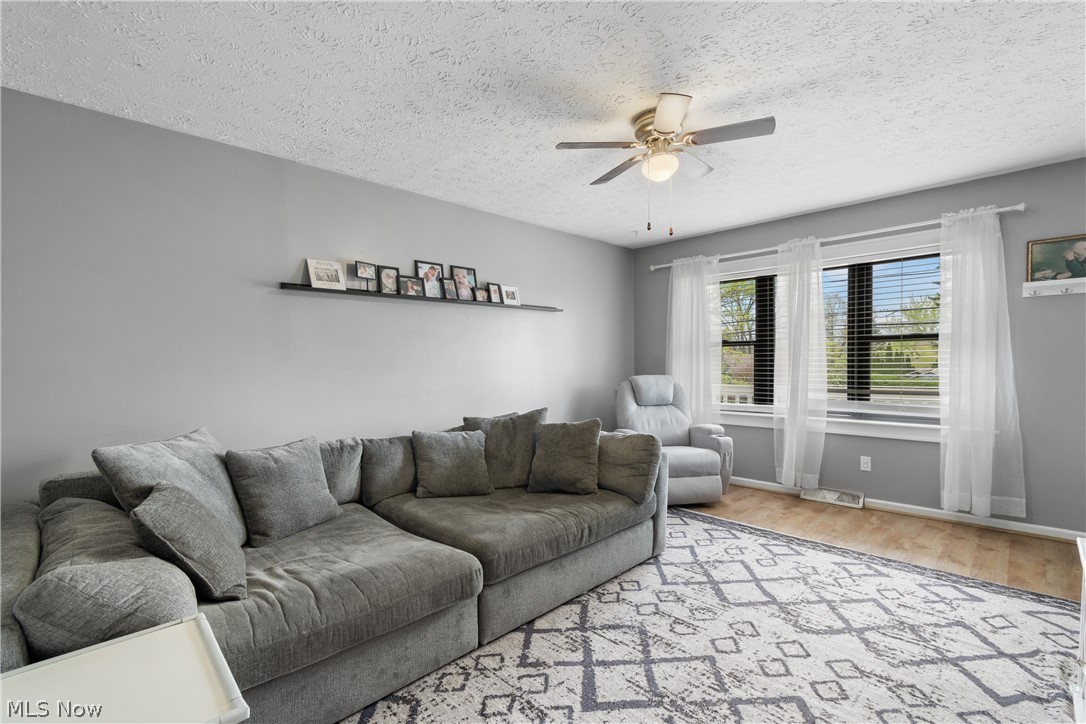 1934 Springfield Center Road Akron, OH 44312 - Photo 6 of 30 Living room with a textured ceiling, light wood-type flooring, and ceiling fan