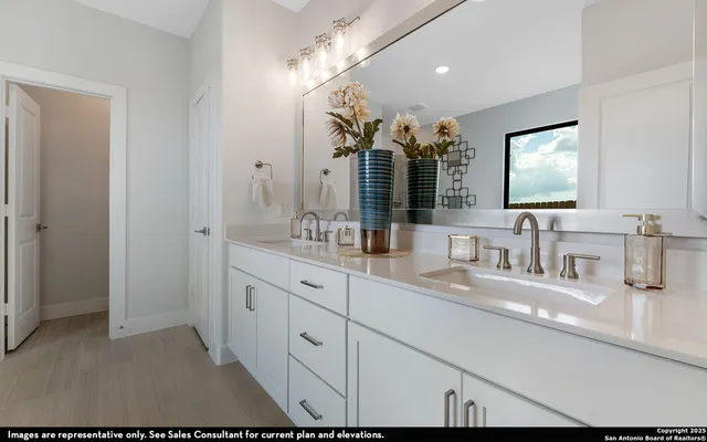 a bathroom with double vanity and a mirror