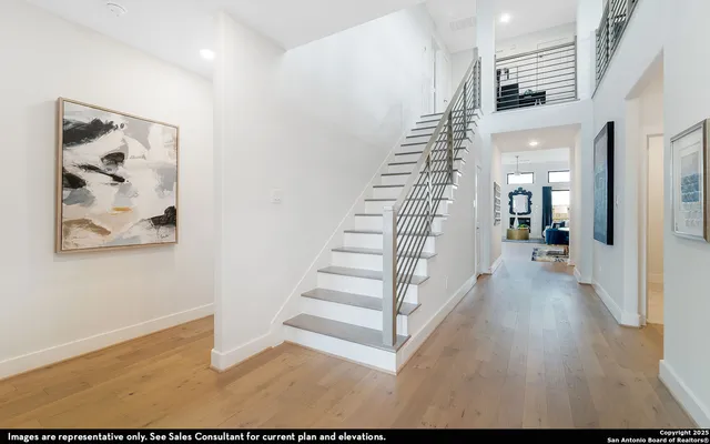 a view of a hallway with wooden floor and stairs