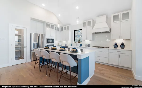 a kitchen with stainless steel appliances kitchen island granite countertop a table chairs sink and cabinets