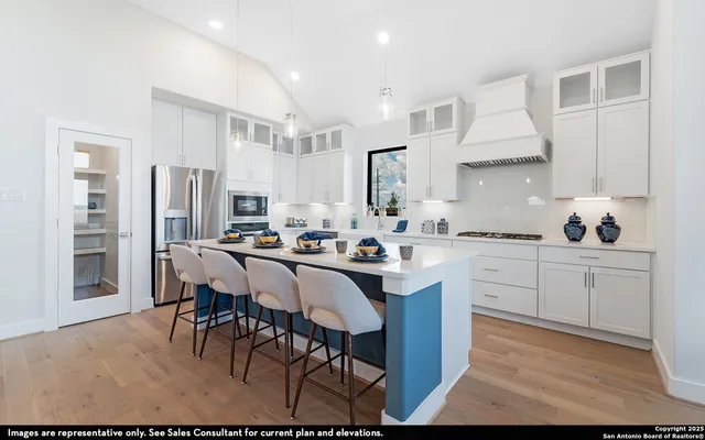 a kitchen with stainless steel appliances kitchen island granite countertop a table chairs sink and cabinets